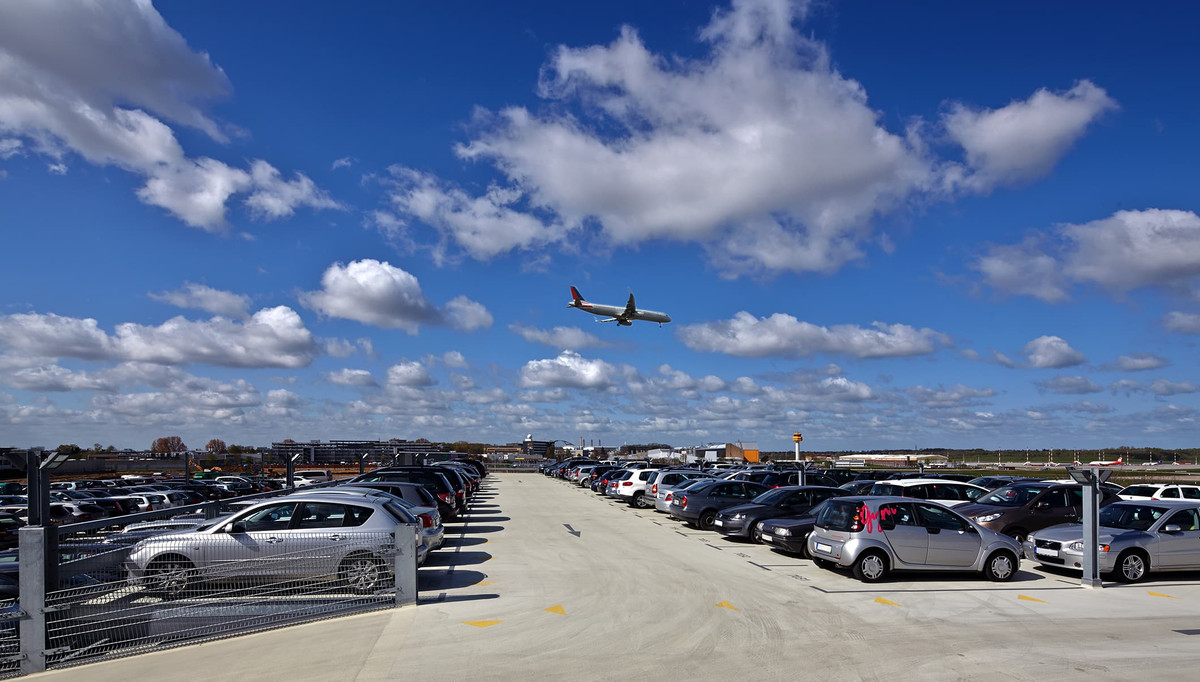 Flugzeug fliegt über Außendeck des Parkhauses von Easy Airport Parking am Flughafen Hamburg (HAM)