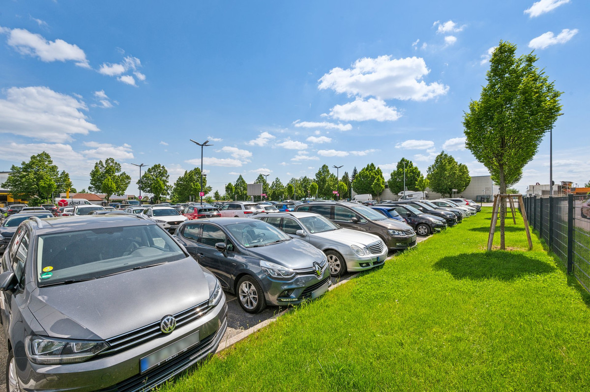 Well-maintained green areas at the edge of the car-filled parking lot of Easy Airport Parking at Stuttgart Airport (STR)